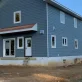 A blue house under construction with a white door and windows photo
